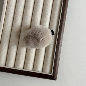 Détail d'une pince à cheveux en peluche beige avec texture douce en fausse fourrure
