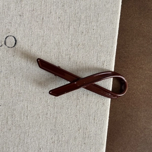 Détail d'une pince à cheveux en résine rouge foncé au design géométrique élégant