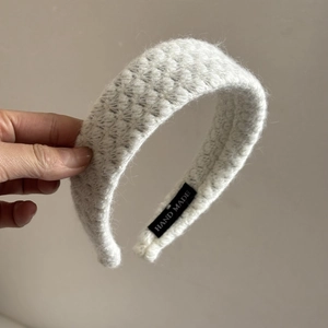 Diadema de felpa tejida en blanco con etiqueta hecha a mano para efecto de altura