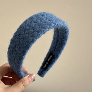 Detalle de la diadema de punto azul Klein con textura artesanal y detalles tejidos