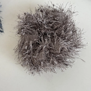 Detailed view of silver-gray textured hair scrunchie with metallic fringe and soft fluffy design