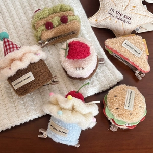 Close-up of cute plush dessert hair clips featuring strawberry cupcakes and sandwiches