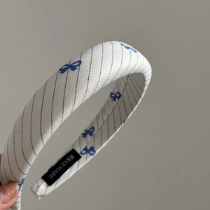 Close-up of fabric headband with blue bow patterns and handmade interior label