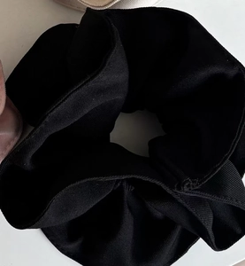 Vue détaillée du chouchou noir en tissu côtelé avec une texture plissée et multicouche