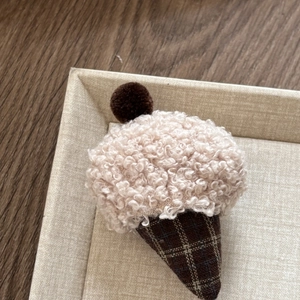 Detailed close-up of handmade ice cream hair clip with soft plush cream and brown cone