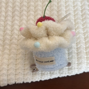 Close-up of cute plush cupcake hair clip with sponge cake tag and cherry detail