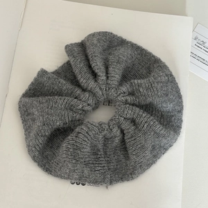 Close-up of deep grey knit scrunchie with soft mohair texture and fluffy design