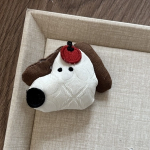 Macro detail of a handmade cartoon dog fabric hairclip with a soft quilted texture