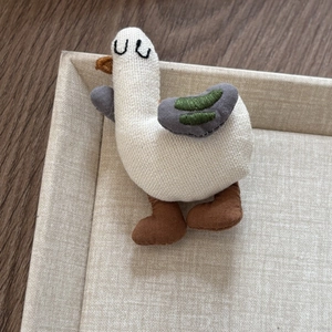 Detail of a handmade fabric seagull hair clip with soft cotton texture and embroidery