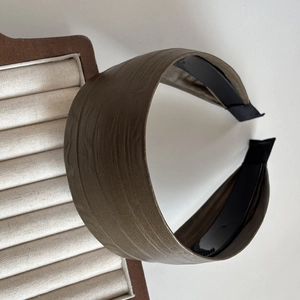 Détail du serre-tête marron foncé montrant la texture cuir brossé et les dents antidérapantes