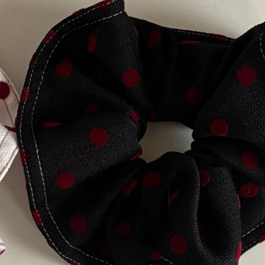 Retro black scrunchie with red polka dots and white contrast stitching detail