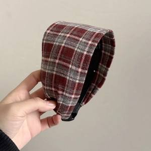 Detail of red and grey plaid padded headband showing thick fabric texture and craftsmanship