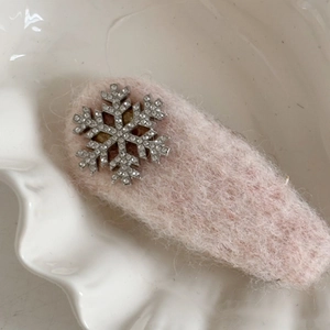 Detailansicht der rosa flauschigen Haarspange mit einer glitzernden Strass-Schneeflocke