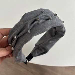 Detail view of grey glitter fabric headband with square rhinestones and padded ends
