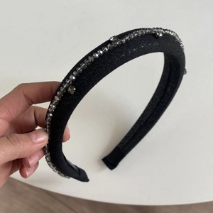 Close-up of wide black glitter headband featuring grey multifaceted crystal beads detail