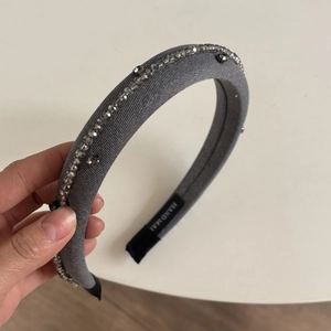 Elegant grey pleated headband featuring sparkling beads and a handmade textile finish
