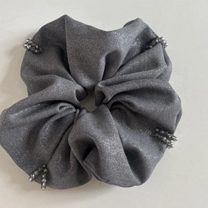 Elegant silver grey pleated scrunchie with metallic texture and dark grey bead accents