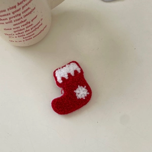 Handmade knitted Christmas stocking hair clip with red and white wool and snowflake embroidery