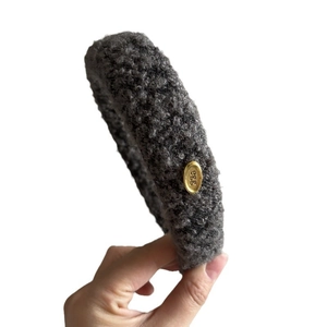 Thick dark gray plush sponge headband with a gold metal tag for a high crown look