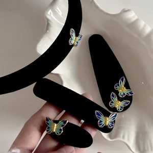 Detailed view of vintage blue velvet butterfly hair clips and headband set in a ceramic dish