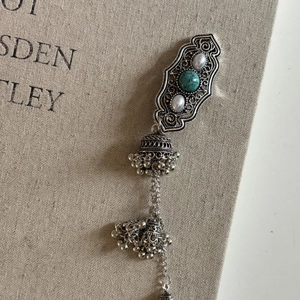 Detailed macro of vintage silver earring with turquoise stone and Jhumka bell pendant