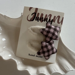 Pink and black plaid gingham star-shaped hair clips set with white fuzzy plush base