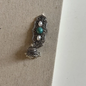 Detail of vintage silver hairpin featuring turquoise bead and pearl tassel accents