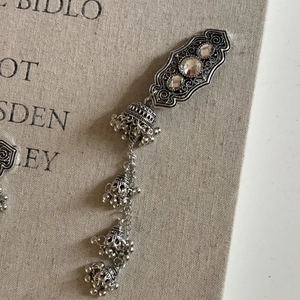 Detail of vintage silver long tassel earrings with sparkling zircons and jhumka bells