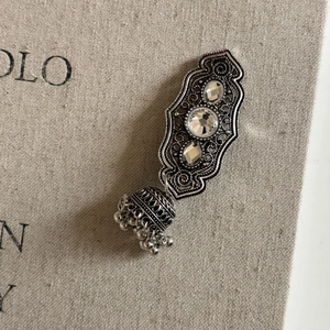 Close-up of vintage silver Jhumka earrings with zircon stones and bell-shaped charms