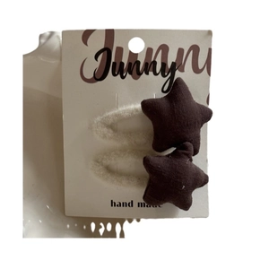 Set of two dark brown fabric star-shaped hair clips for girls on a Sunny display card