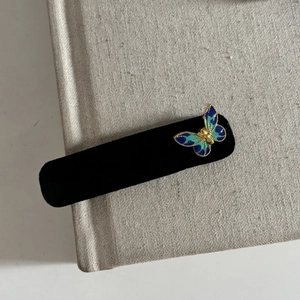 Vintage black velvet hair clip with blue enamel butterfly and gold metal edging