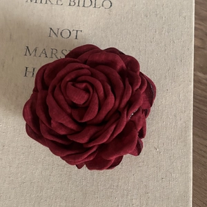 Detailed close-up of large burgundy rose hair claw clip made of layered fabric petals