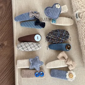 Flat lay of handmade assorted blue denim and plaid fabric hair clips with cute buttons