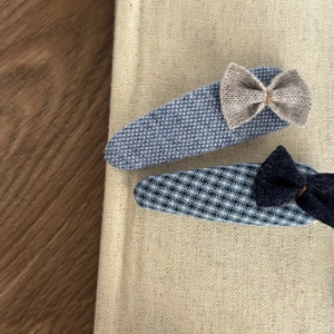Close-up of handmade blue sea salt hair clips with lace buttons and plaid heart detail