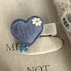 Detail of blue denim heart hairclip with daisy flower and small bear pendant