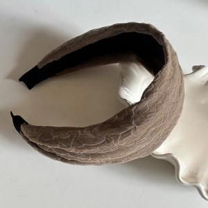 Detail of beige lace embossed thick headband texture on white decorative tray