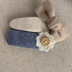 Close-up of handmade blue and beige hair clips with lace flowers and wooden buttons