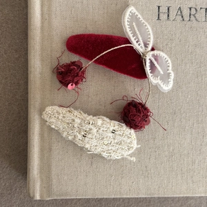 Detalle de horquillas de terciopelo rojo y tweed con borlas de lentejuelas