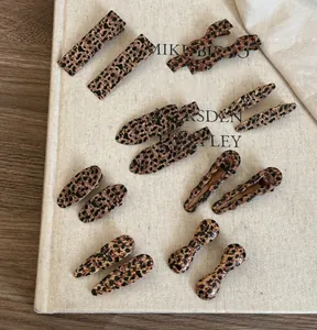Flat lay of retro leopard print resin hair clips in various geometric shapes on book