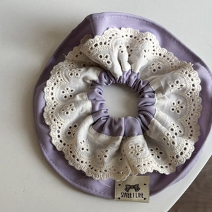 Détail d'un chouchou violet avec bordure en dentelle blanche et étiquette Sweet Life