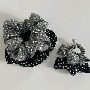 Detail of silver sequin fabric scrunchies and bow phone cord hair ties in black and silver