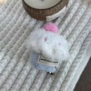 Detail view of a cute plush cupcake hair clip with sponge cake text label on soft knit