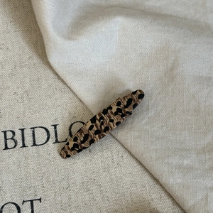 Vintage leopard print acetate hair clip for women with minimalist linen background