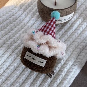 Detail view of plush sponge cake earphone case on a white knitted background