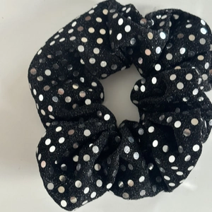 Black scrunchie with silver sequins and glitter fabric showing elastic pleated texture