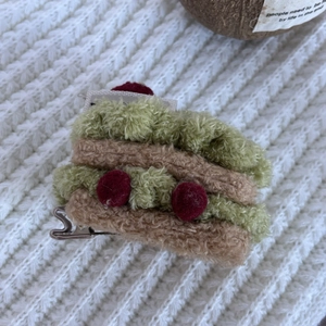 Close-up of soft plush cake hair clip with sandwich design on knit background