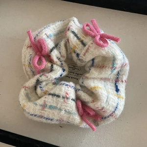 White fuzzy plaid scrunchie hair tie with pink bows and colorful grid patterns