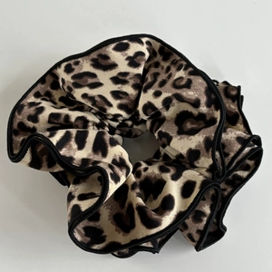 Detailed view of large leopard print scrunchie with durable black stitched edge finish