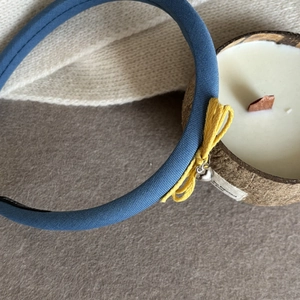 Gros plan détaillé d'un bandeau en dentelle bleue avec nœud jaune et pendentif cœur argenté