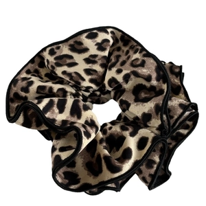 Leopard print scrunchie with black piping and textured wavy folds on white background
